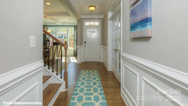 a view of a hallway with wooden floor and staircase