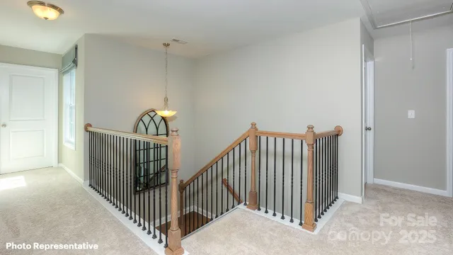 a view of staircase with railing and white walls