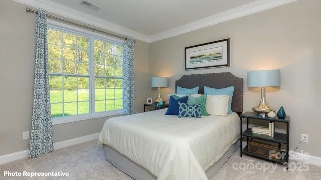 a bedroom with a bed and a lamp next to a window