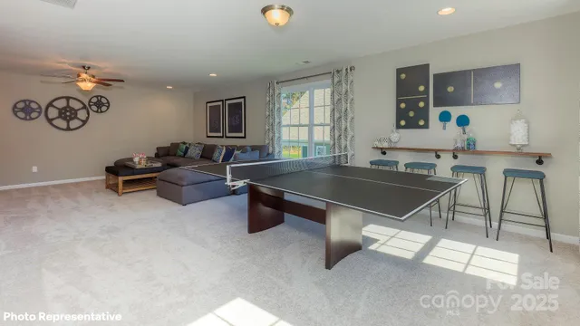 a living room with a table and chairs with wooden floor