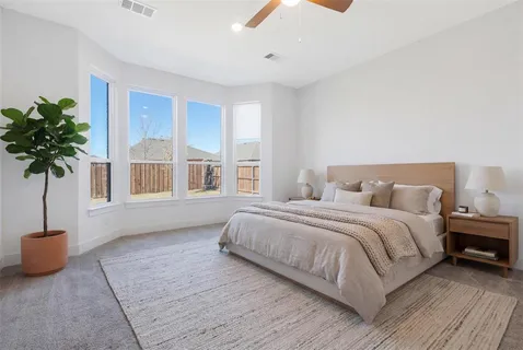 a spacious bedroom with a bed and a window