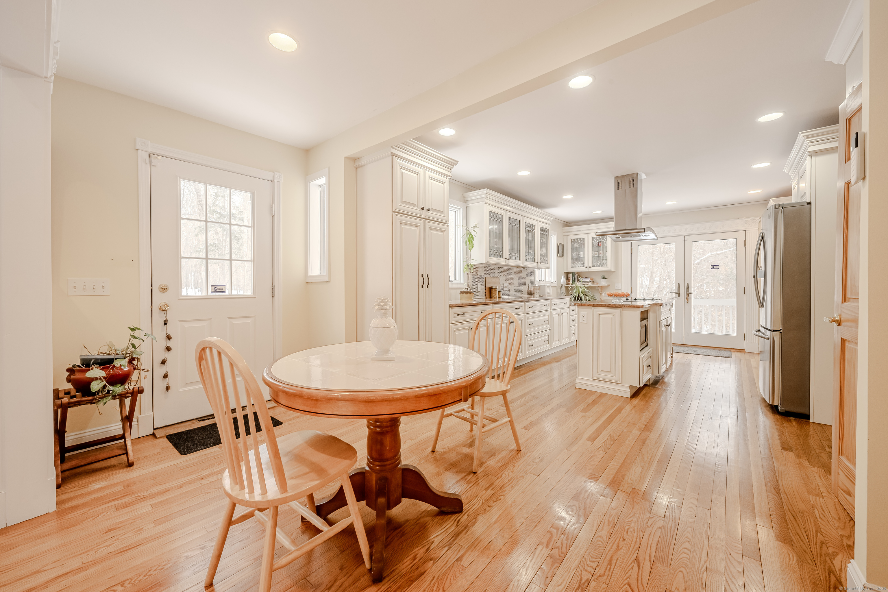 305 Rimmon Road Woodbridge, CT 06525 - Photo 11 of 28 a living room with stainless steel appliances kitchen island granite countertop furniture and wooden floor