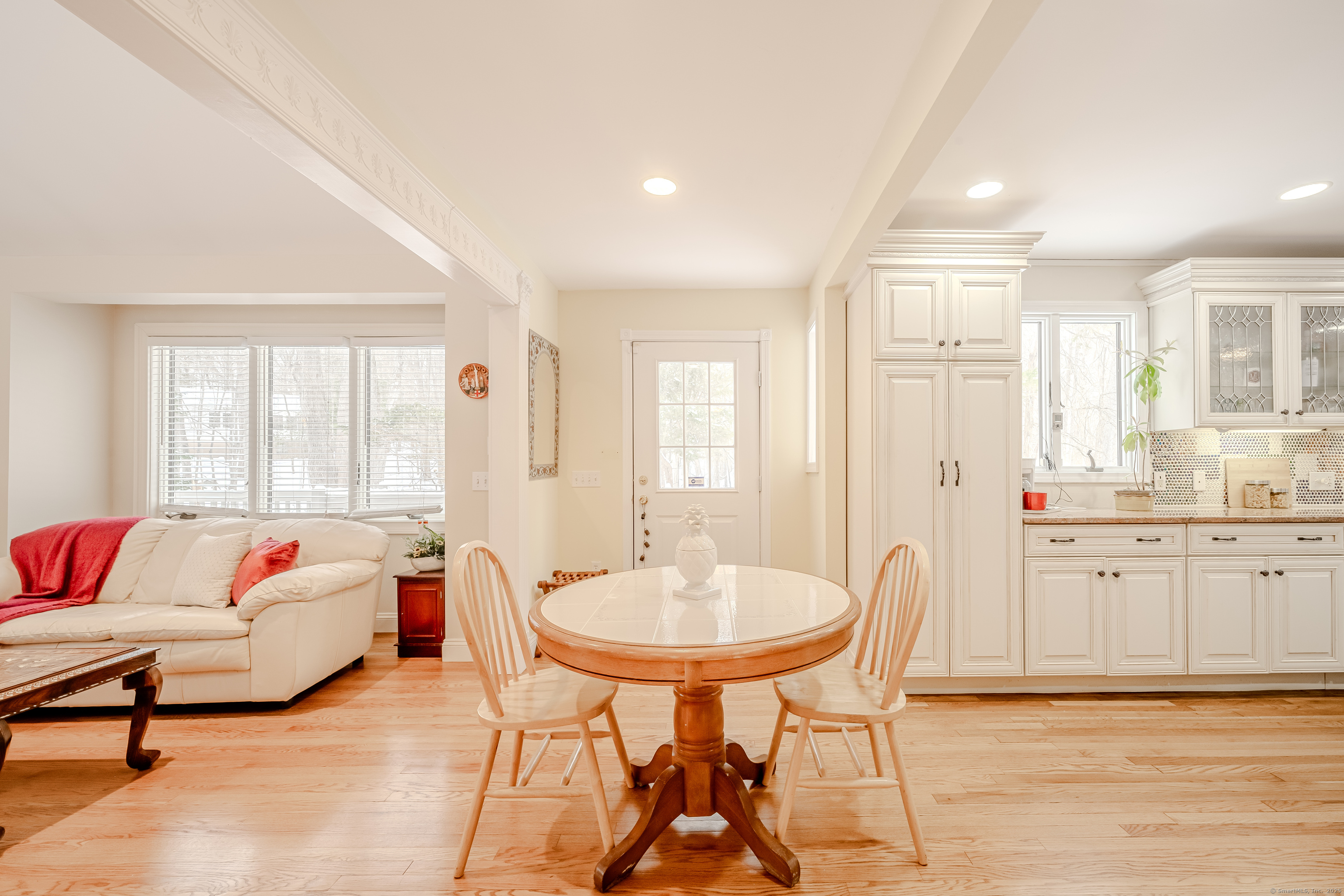 305 Rimmon Road Woodbridge, CT 06525 - Photo 12 of 28 a living room with furniture and a dining table with wooden floor
