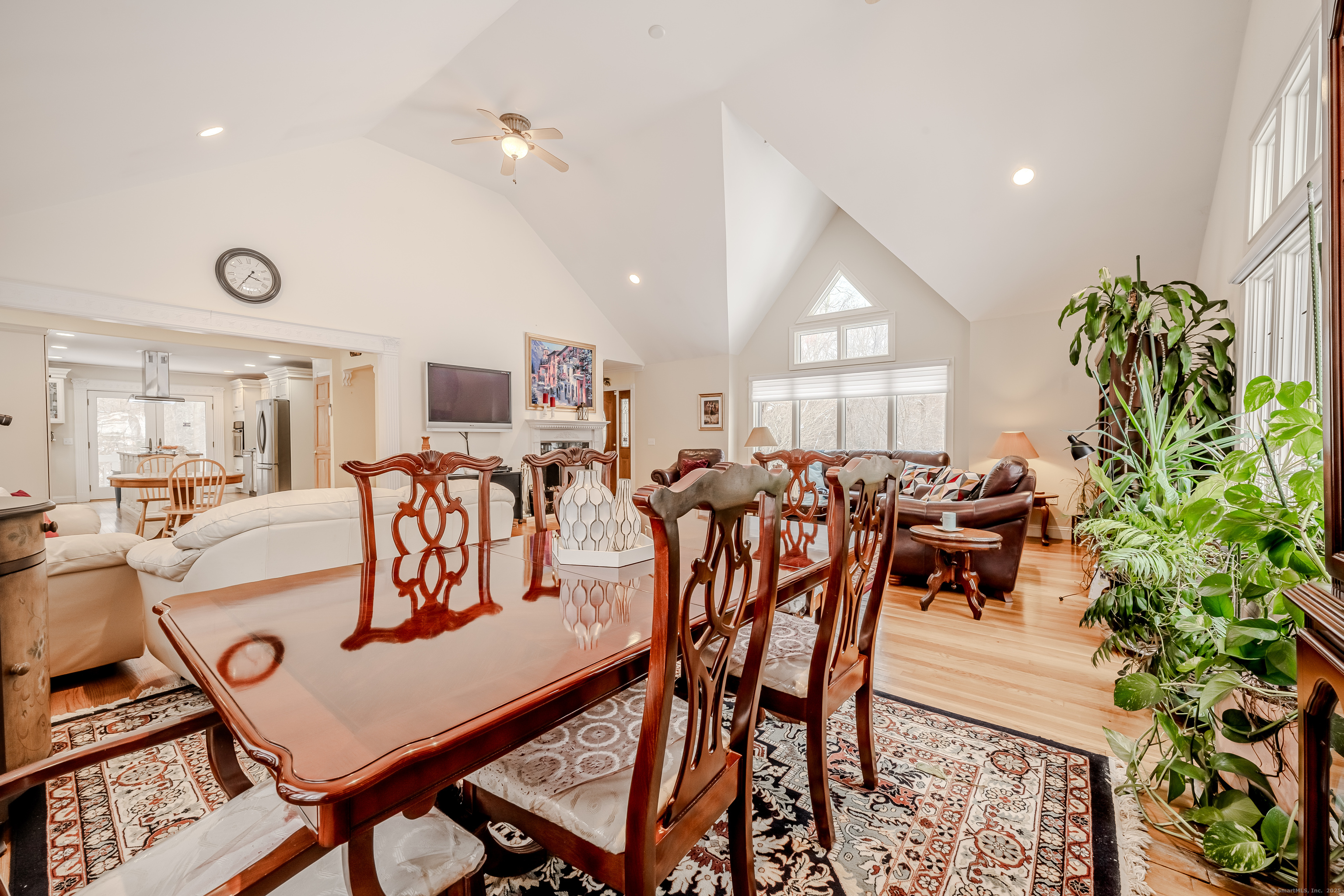 305 Rimmon Road Woodbridge, CT 06525 - Photo 5 of 28 a view of a dining room and livingroom with furniture a rug a potted plant and windows