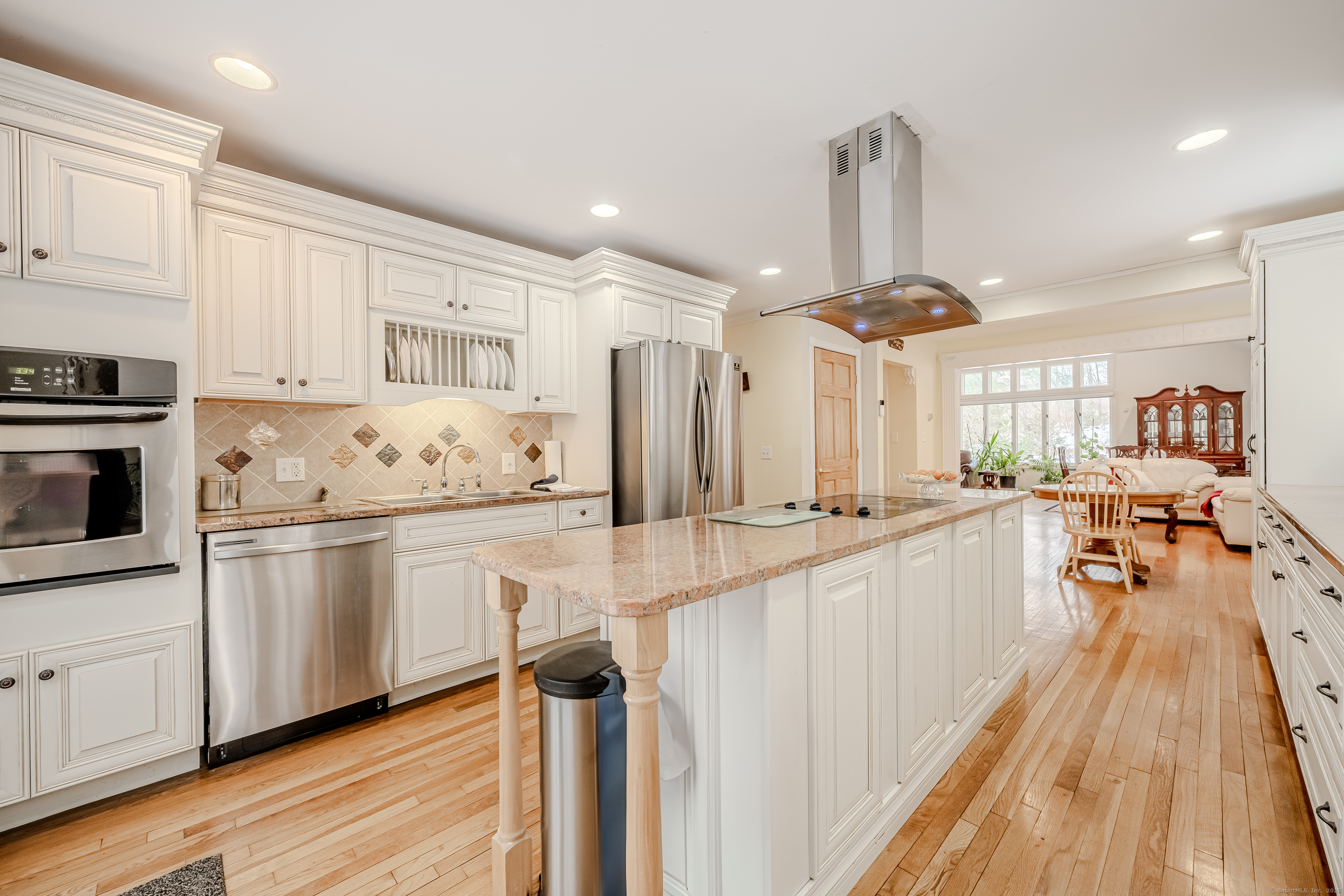 305 Rimmon Road Woodbridge, CT 06525 - Photo 9 of 28 a kitchen with white cabinets appliances and wooden floor