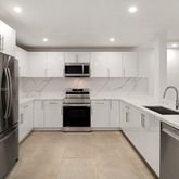a kitchen with stainless steel appliances a refrigerator sink and microwave