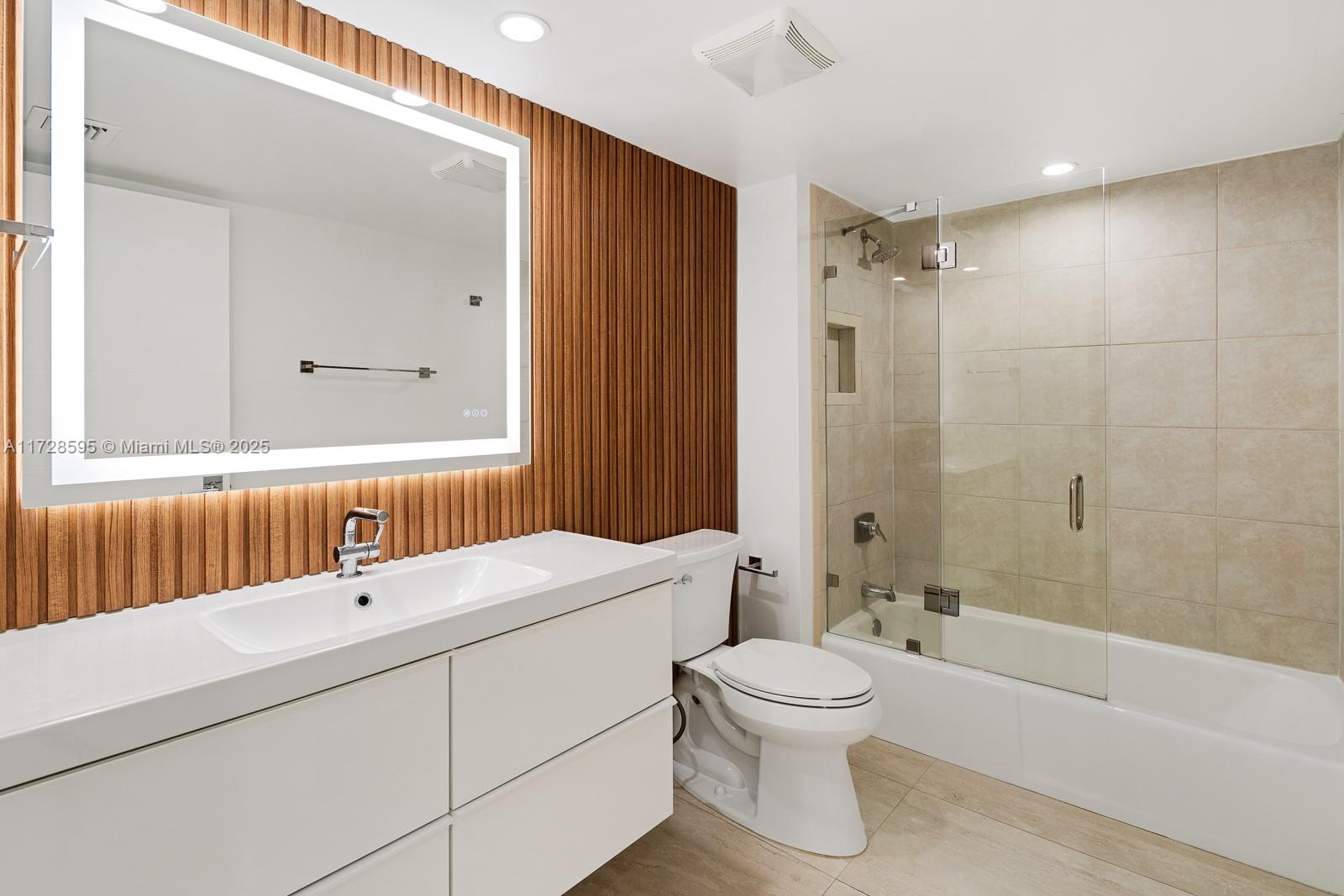 141 Crandon Boulevard, Unit 229 Key Biscayne, FL 33149 - Photo 18 of 30 a bathroom with a toilet a sink a mirror and a bathtub