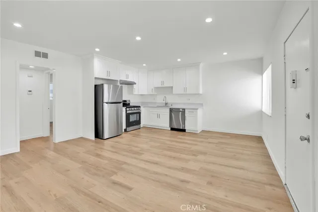 a view of a kitchen with a sink and a refrigerator
