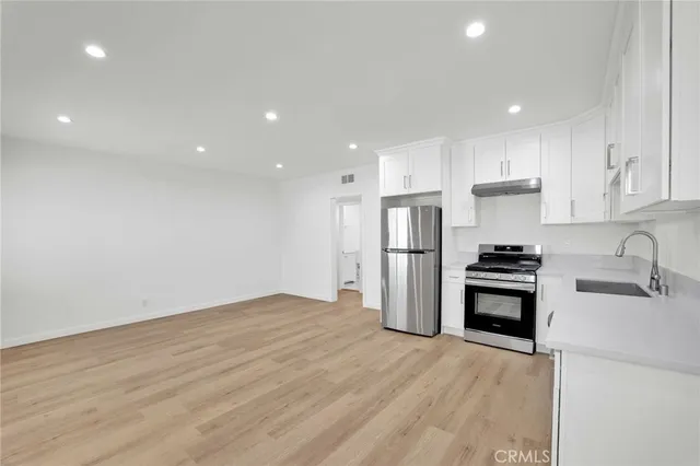 a kitchen with stainless steel appliances granite countertop a refrigerator sink and stove