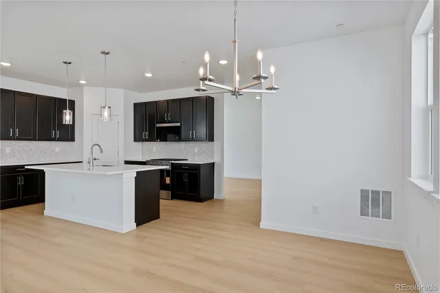 a large white kitchen with a stove top oven a sink and dishwasher