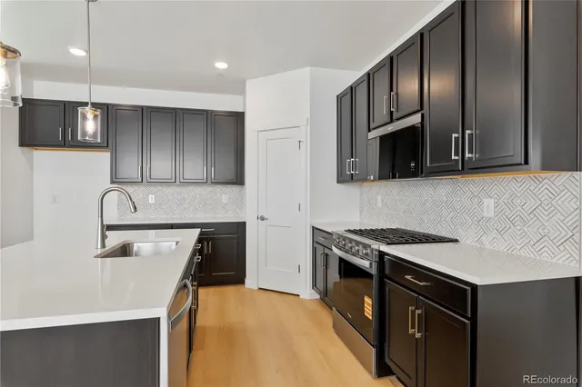 a kitchen with stainless steel appliances granite countertop a sink stove microwave and refrigerator