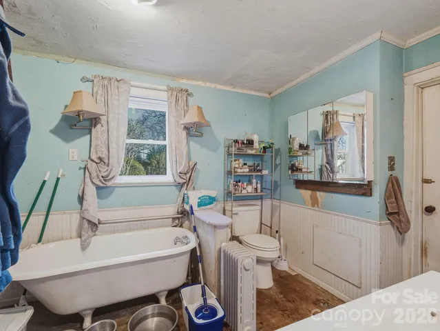 a bathroom with a tub a sink and a large mirror
