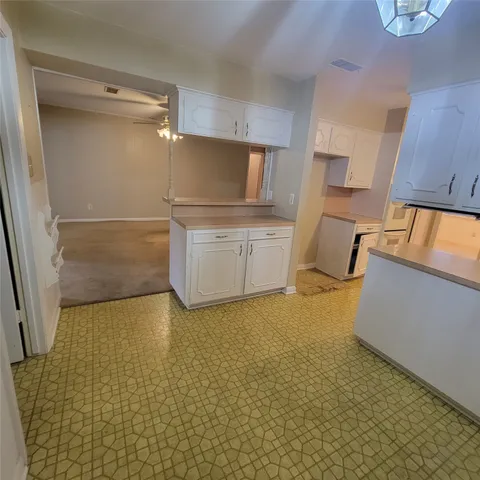 a room with wooden floor and cabinets