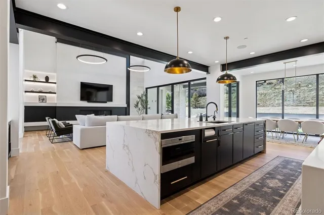 a large kitchen with stainless steel appliances kitchen island granite countertop a lot of cabinets a sink and a couch