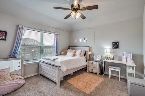 a bedroom with a bed a chandelier and a window