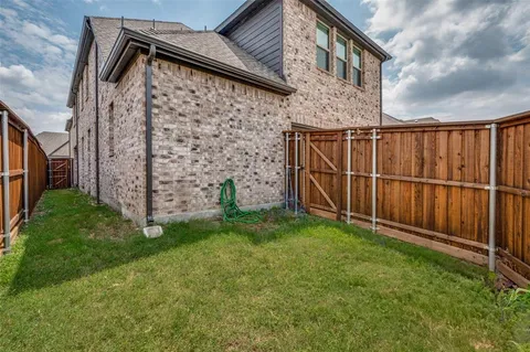 a view of a backyard with wooden fence