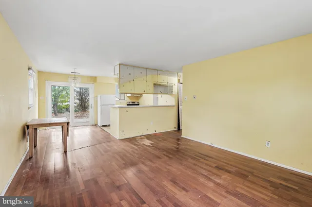 a view of a kitchen with wooden floor and a refrigerator