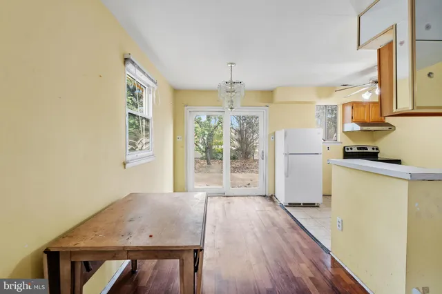 a kitchen with a wooden floor and a refrigerator