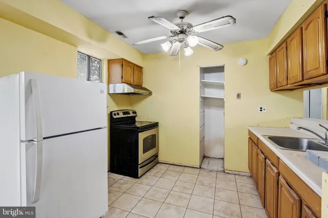 a kitchen with stainless steel appliances granite countertop a refrigerator a sink dishwasher a stove with white cabinets