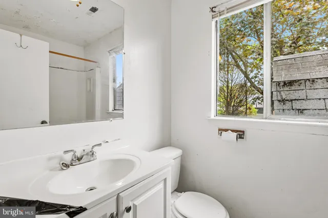 a bathroom with a sink and mirror with toilet