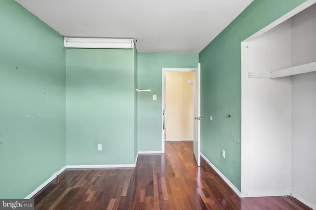 a view of a room with wooden floor and a bathroom