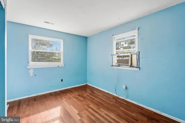 a view of a room with wooden floor and windows