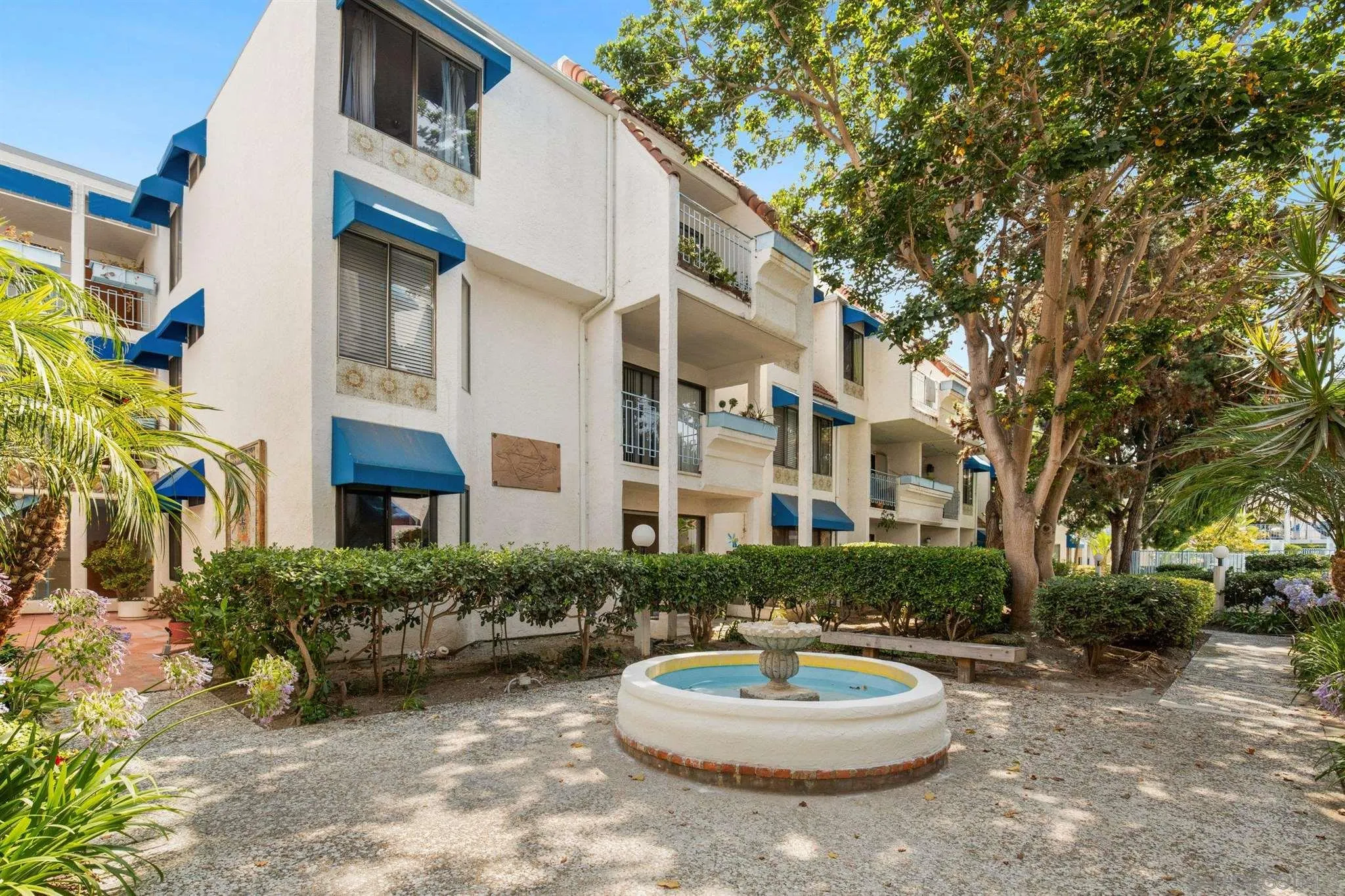 8308 Regents Road, Unit 1H San Diego, CA 92122 - Photo 2 of 14 a backyard of a house with a fountain and a table and chairs