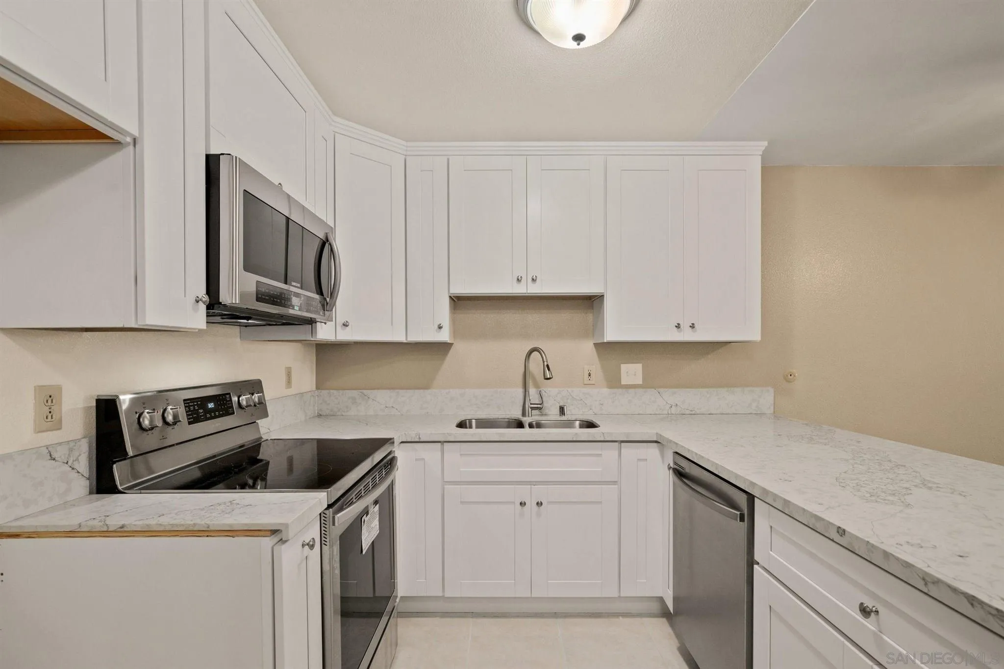 8308 Regents Road, Unit 1H San Diego, CA 92122 - Photo 6 of 14 a kitchen with stainless steel appliances granite countertop a sink a stove and cabinets