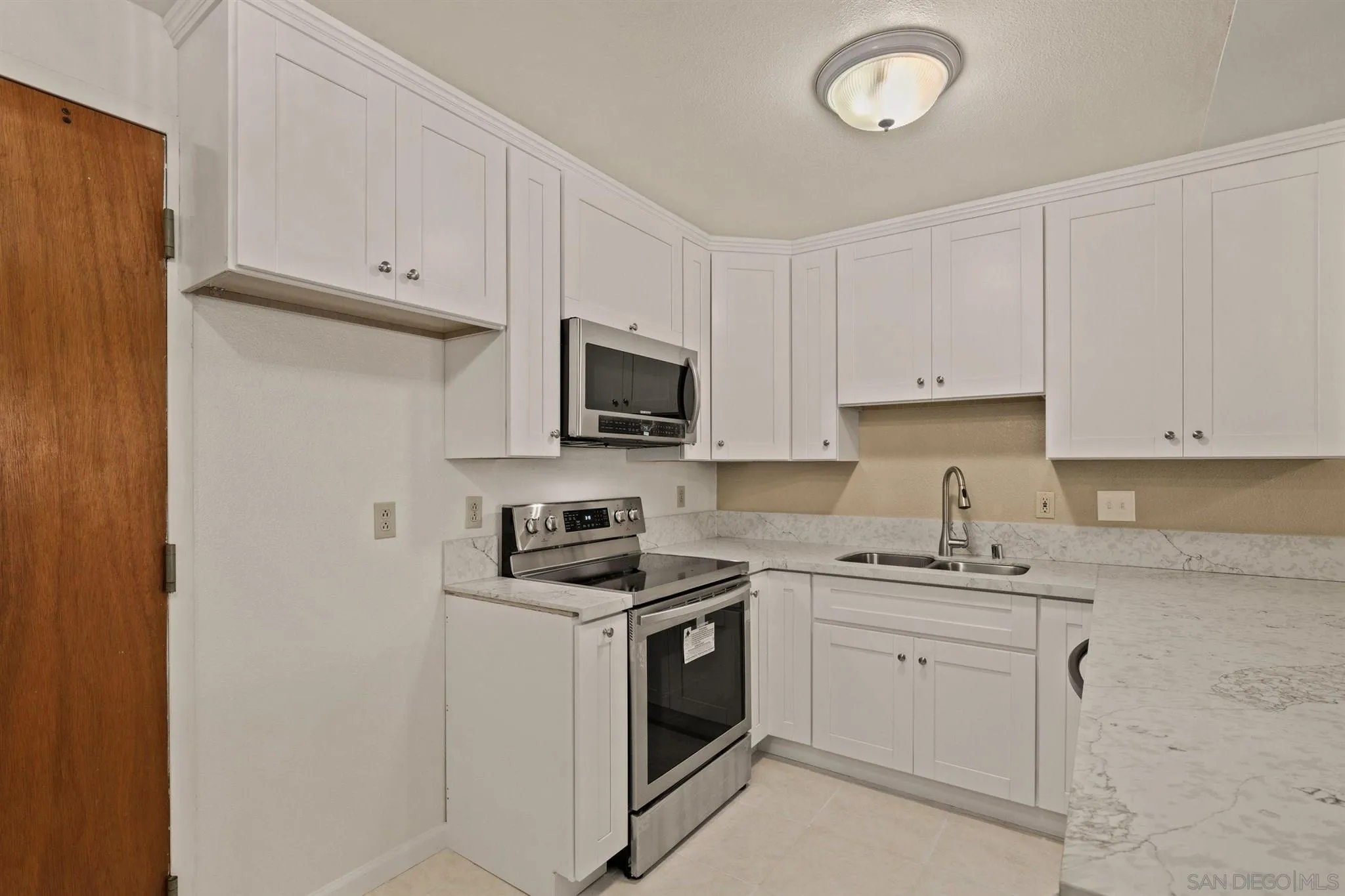 8308 Regents Road, Unit 1H San Diego, CA 92122 - Photo 7 of 14 a kitchen with appliances a sink and cabinets