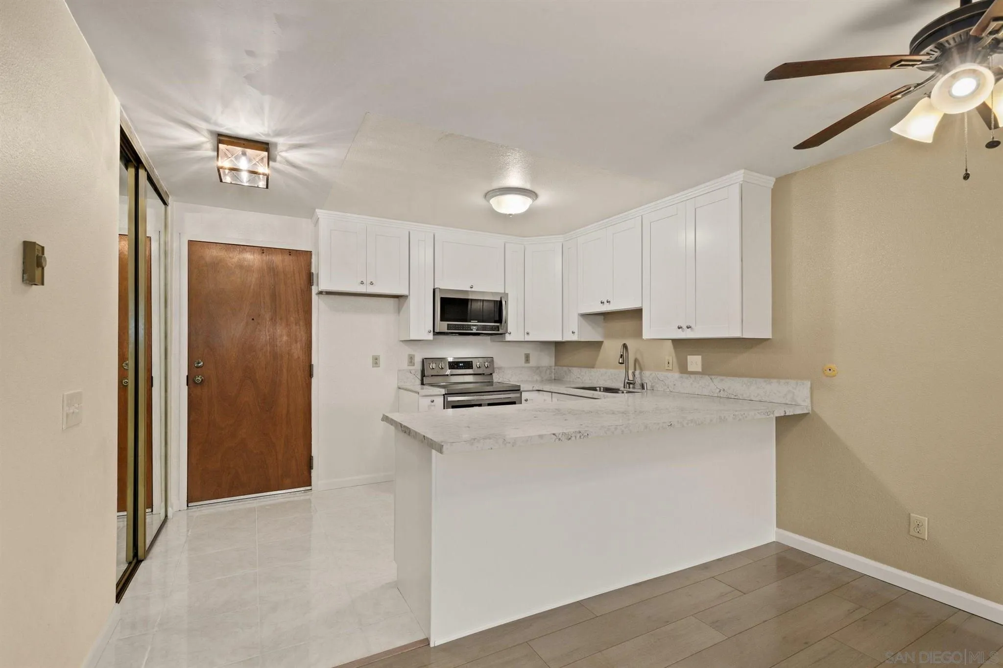 8308 Regents Road, Unit 1H San Diego, CA 92122 - Photo 8 of 14 a kitchen with stainless steel appliances cabinets a sink and a refrigerator