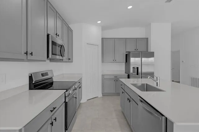 a kitchen with stainless steel appliances granite countertop a sink stove and refrigerator