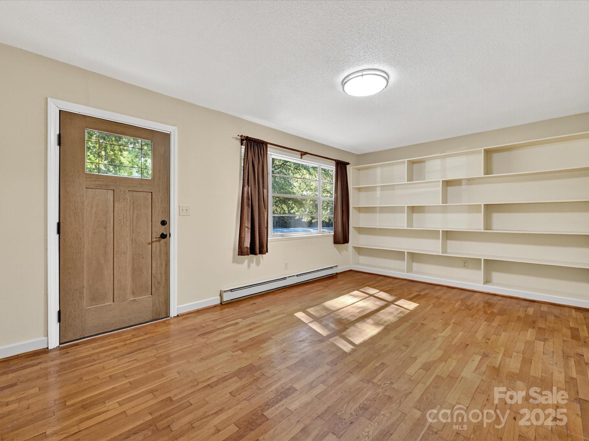 341 Camp Creek Road Iron Station, NC 28080 - Photo 12 of 29 a view of an empty room with a window and wooden floor