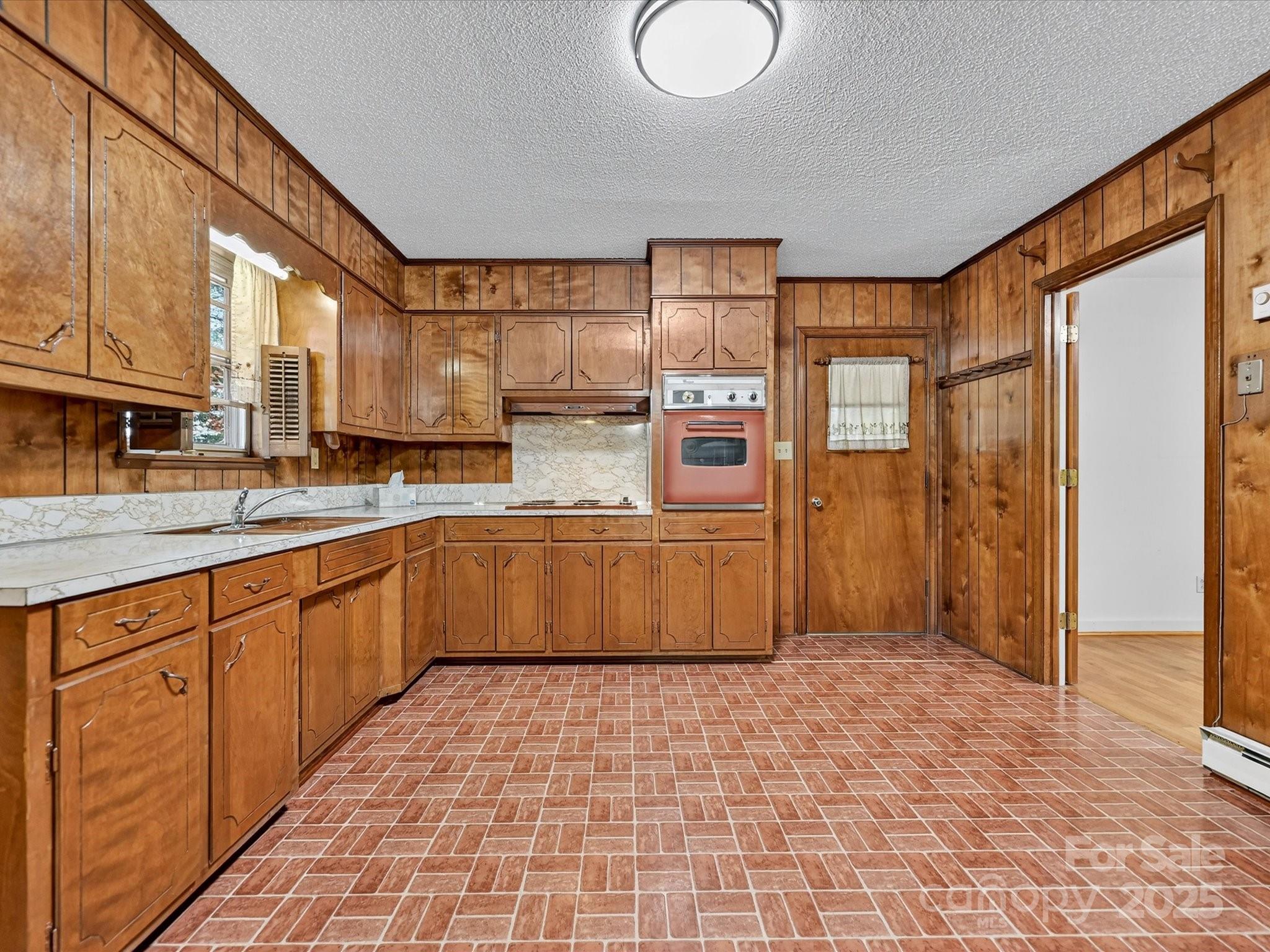 341 Camp Creek Road Iron Station, NC 28080 - Photo 19 of 29 a large kitchen with stainless steel appliances a large counter top a stove a chimney a sink and cabinets