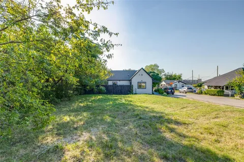 a view of yard with green space and trees in the background