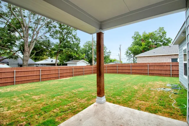 a front view of house with yard and trees in the background