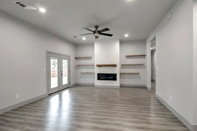 wooden view of empty room with wooden floor and ceiling fan