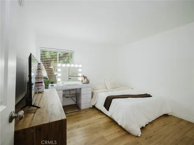 a bedroom with a bed and a flat tv screen on the table