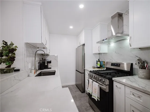 a kitchen with stainless steel appliances granite countertop a sink a stove and a refrigerator