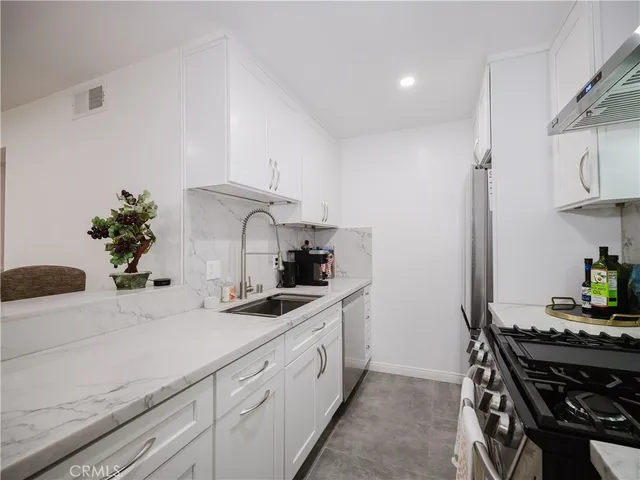 a kitchen with stainless steel appliances a sink a stove and cabinets