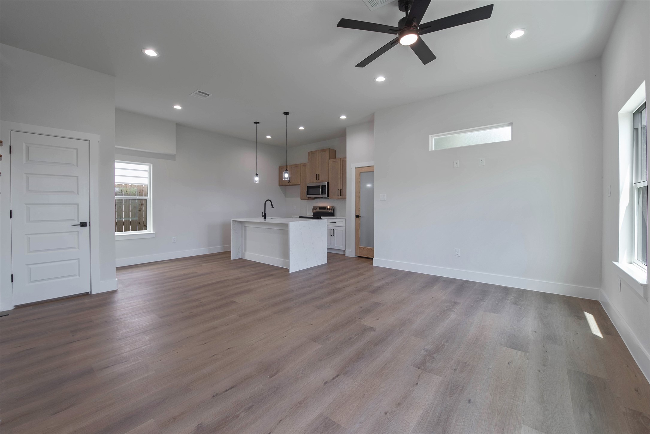 The front door opens to a spacious open-concept living, dining, and kitchen area, thoughtfully designed for effortless entertaining, with a convenient half bath on the first floor.