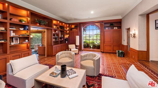 a living room with fireplace furniture and a large window