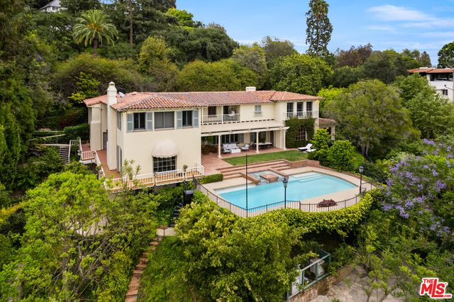 a view of a house with pool and trees