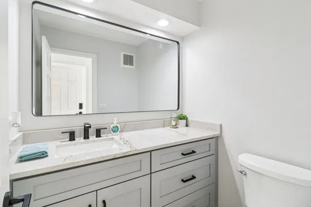 a bathroom with a granite countertop sink and a mirror