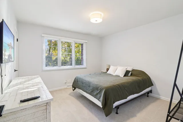 a bedroom with a bed and a large window