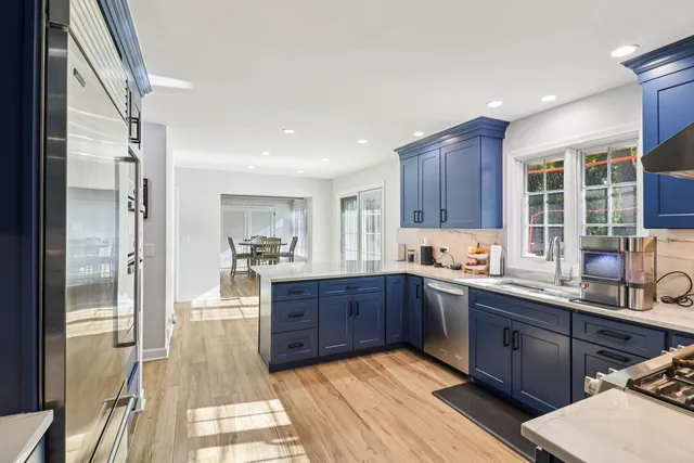 a large kitchen with wooden floors and stainless steel appliances