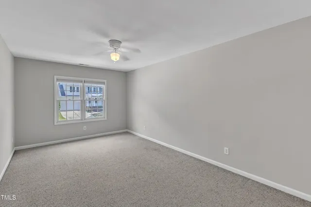 a view of an empty room with a chandelier fan