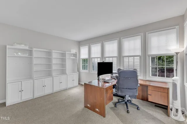 a view of a workspace with furniture and a window