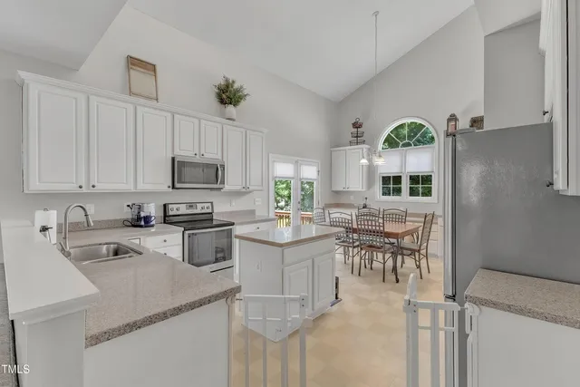 a kitchen with cabinets and chairs