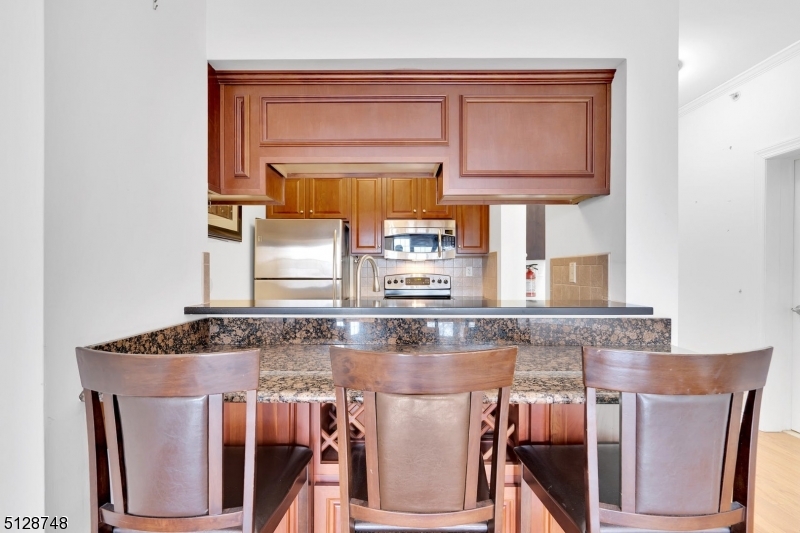 7 Prospect Street, Unit 303 Morristown, NJ 07960 - Photo 11 of 22 a kitchen with stainless steel appliances granite countertop a stove a sink and a microwave