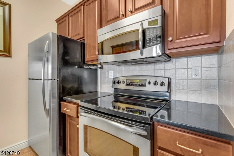 7 Prospect Street, Unit 303 Morristown, NJ 07960 - Photo 12 of 22 a kitchen with a refrigerator stove and microwave